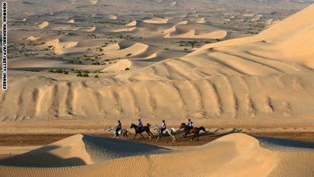 Participants ride horses across sand dunes during the Sheikh Sultan Bin Zayed al-Nahyan International Equestrian festival in the Boudthib Endurance Village near the Emirati capital Abu Dhabi on March 16, 2013. AFP PHOTO/MARWAN NAAMANI (Photo credit should read MARWAN NAAMANI/AFP/Getty Images)