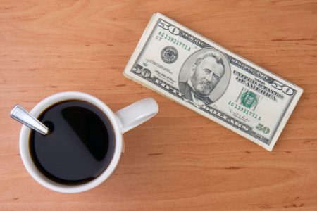 BCFGB7 coffee cup and money on wooden background