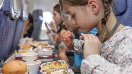 Girl about to eat airline meal --- Image by © PhotoAlto/Corbis