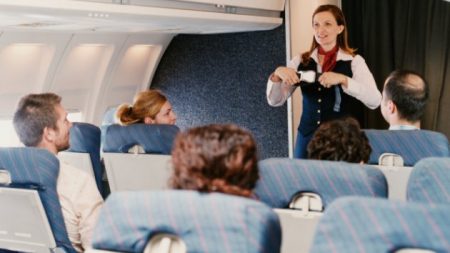 Female Flight Attendant Demonstrating Safety Procedures to Passengers on a Plane