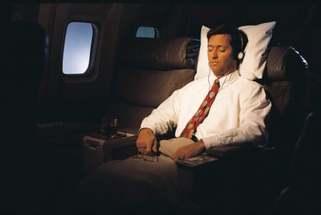 Businessman Sleeping on a Commercial Aeroplane