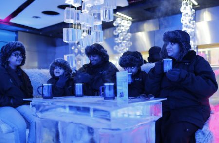 A Saudi Arabian family drinks hot chocolate at Chillout cafe in Dubai May 12, 2013. Chillout, owned by UAE's Sharaf Group, is the first ice lounge in the Middle East, with temperatures set at -6 degrees Celsius (21 degrees Farenheit). The cafe, with its illuminated interiors, curtains, paintings and seating arrangements, is all made of carved ice and frozen sculptures. Picture taken May 12, 2013. REUTERS/Ahmed Jadallah (UNITED ARAB EMIRATES - Tags: SOCIETY)